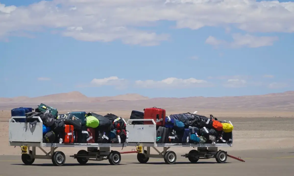 Luggage carts loaded with suitcases outside an airport