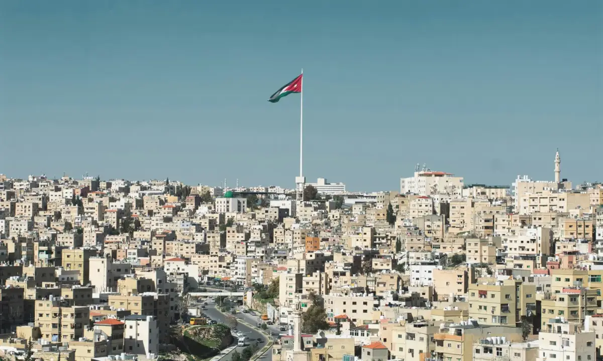 Amman’s hills, limestone buildings and the Jordanian flag