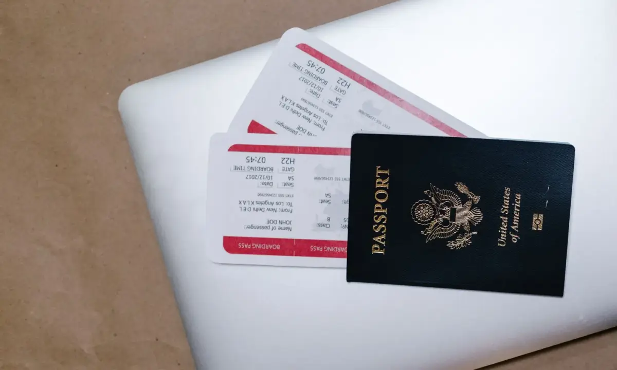 A passport and travel documents on a laptop