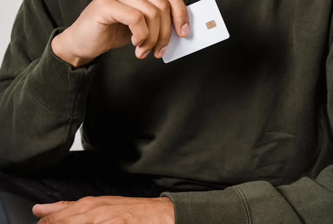 Using a bank card beside a laptop