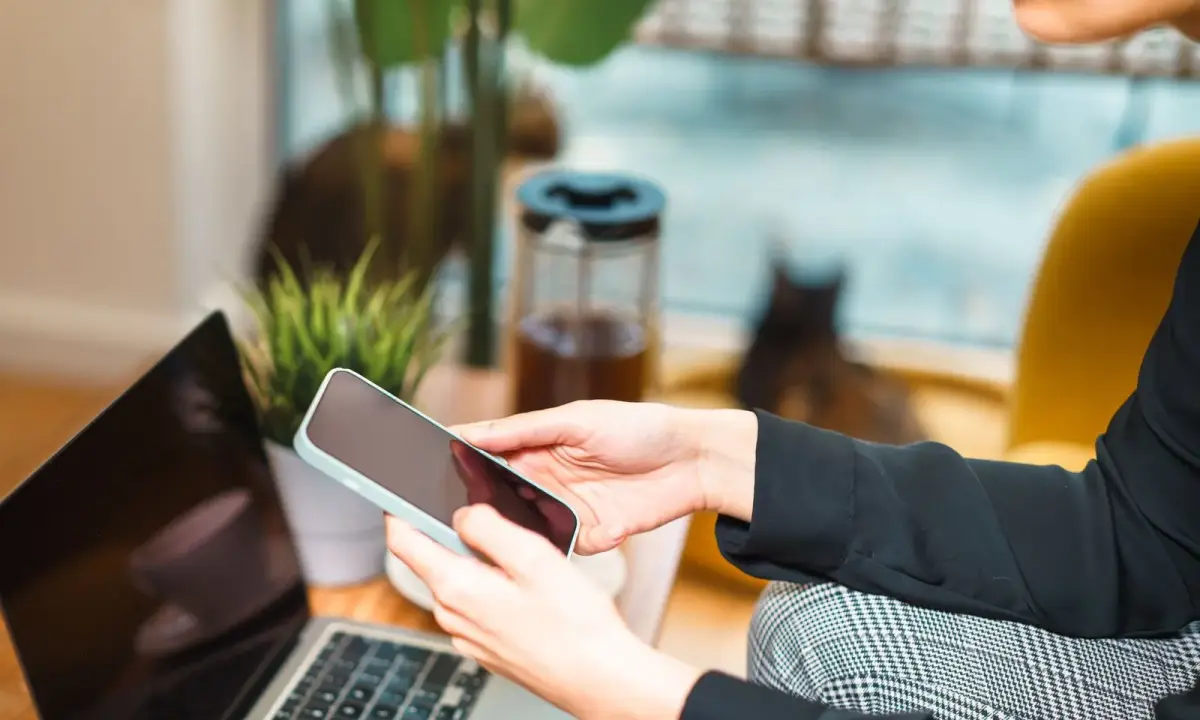 Using a phone beside a laptop