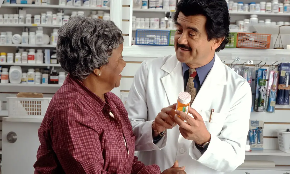 A pharmacist explaining a prescription. Illustrative photograph from the United States; not an Amman pharmacy.